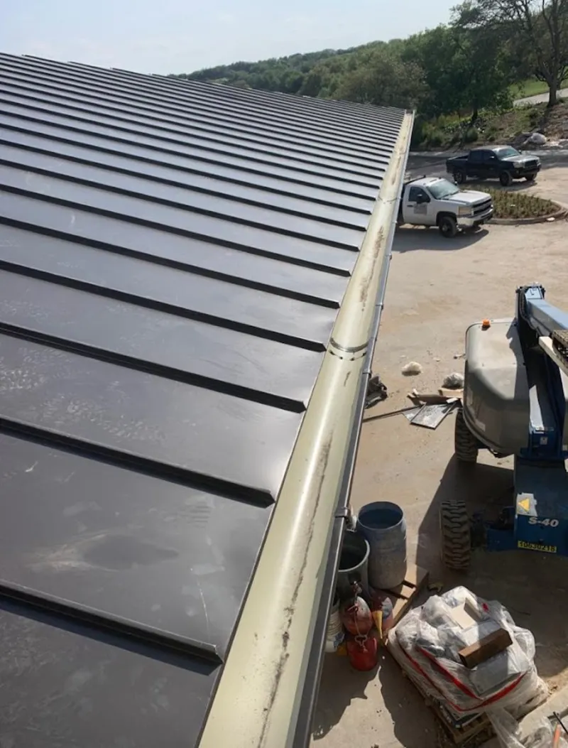 Standing seam panel and gutter detail on a metal roofing jobsite in Lancaster